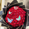 Bouquet of red roses with butterfly decorations and a small crown topper