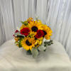 Bouquet of sunflowers and red roses in a square glass vase