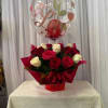 Red and white roses in red wrapping with a heart balloon above