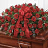 A lush cascade of deep red roses laid across a polished wooden
