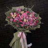 Large bouquet of pink and purple roses wrapped in olive paper