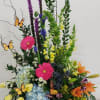 Tall mixed flower basket with butterflies and bright blooms