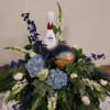 Floral arrangement with blue and white flowers around a bowling pin and ball