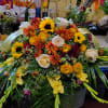 Large mixed floral arrangement with sunflowers, roses, and mums