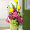 Pink roses and yellow tulips in a green basket vase