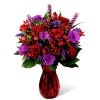 Red and purple mixed bouquet in a red glass vase