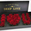 Red roses arranged in a black gift box spelling "DEEP LOVE"