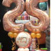 Rose-gold number 25 balloons with a Happy Birthday balloon and small gold balloons.