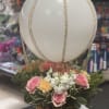Basket arrangement with pink roses and white flowers beneath a large white balloon
