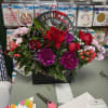 Birthday flower arrangement in a black gift box with red roses and purple blooms