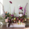 Mixed floral arrangement in a white rectangular box with pink and purple blooms
