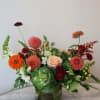A fall inspired floral arrangement with seasonal blooms in a warm, light