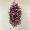 Tall standing floral spray in purple, pink, and magenta tones
