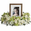 White floral photo frame arrangement with a portrait in the center