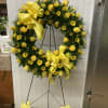 Yellow rose and daisy wreath on a standing easel with ribbon bows