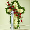 Cross-shaped floral spray with red roses and white chrysanthemums on a stand