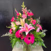 Pink lilies and gerbera daisies in a glass vase