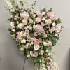 Large pink and white floral standing arrangement on a stand