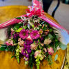 Bouquet of pink and purple flowers wrapped in pink paper with a bow