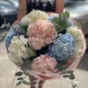 Bouquet of pastel hydrangeas with eucalyptus in pink wrapping