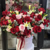 Large bouquet of red and pink roses with white lilies in a white hat box