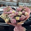Bouquet of pink and cream roses wrapped in pastel paper