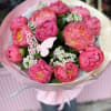 Pink peony bouquet wrapped in pale pink paper with a butterfly decoration