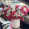 Pink roses and white orchids in a white hatbox with ribbon
