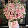 Pink roses and white orchids arranged in a pink hat box