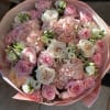 Pink and white bouquet of roses, hydrangeas, and ranunculus wrapped in pink paper