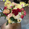 Bouquet of yellow orchids, red roses, and pink tulips