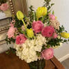 Pink and white bouquet with yellow tulips in a glass vase