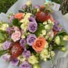 Bouquet of lavender, peach, and pink roses with pale cream blooms