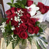 Bouquet of red roses with white orchids and baby's breath in a glass vase