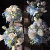 Four blue and white floral bouquets with ribbon on a wooden surface
