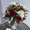 Bouquet of red roses and white tulips in a clear glass vase