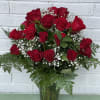 Bouquet of red roses with baby's breath in a glass vase