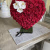 Heart-shaped arrangement of red roses with white orchids