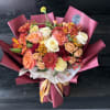 Mixed bouquet of roses, chrysanthemums, and alstroemeria wrapped in pink paper