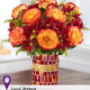 Orange roses and burgundy daisies in a mosaic glass vase