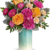 Bouquet of pink and orange flowers in a turquoise vase