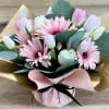 Bouquet of pink gerbera daisies and white tulips wrapped in gold and pink paper
