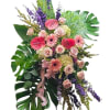 This standing spray features a vibrant and diverse array of flowers, meticulously