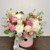 Pink and white rose bouquet in a pink hat box with ribbon.