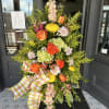 Tall floral standing spray with orange roses and yellow chrysanthemums