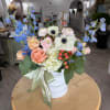 Mixed pastel bouquet in a white hatbox with blue delphinium and roses