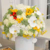 Large white floral arrangement with yellow and red roses in a white hatbox