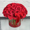 Red rose bouquet in a clear round vase with a red ribbon