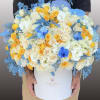 Large bouquet of white, yellow, and blue roses in a white box