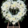 Heart-shaped white floral wreath on a wooden easel